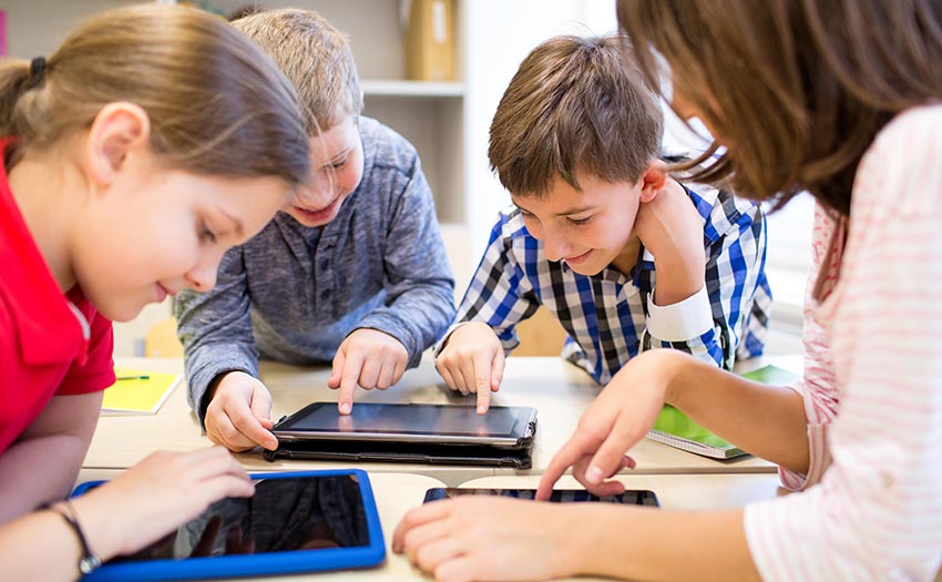 Schüler arbeiten gemeinsam mit digitalen Geräten im Unterricht.