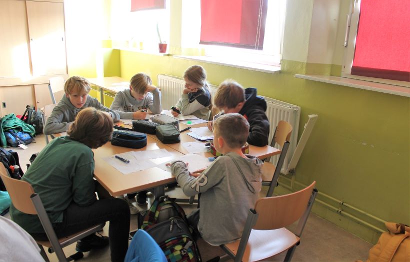 In einem Klassenzimmer sind die Schüler:innen mit Recherche beschäftigt.