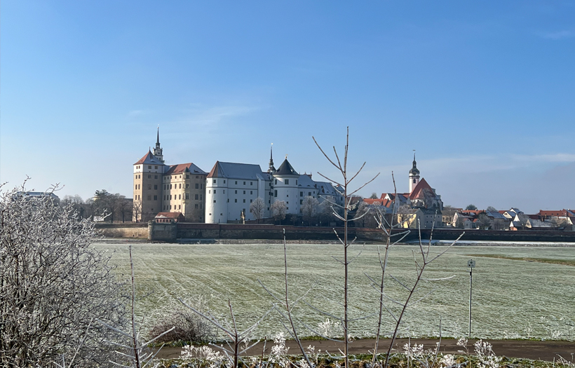 Das Gebäude des Jugendwerkhofes Torgau von außen fotografiert. Maßige Mauern und hohe Türme erinnern an ein Gefängnis-