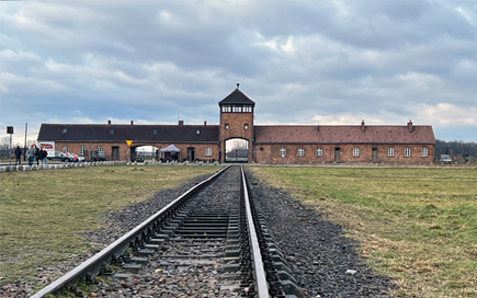 Ansicht des Konzentrationslagers Auschwitz/Birkenau mit Gleisen im Vordergrund.